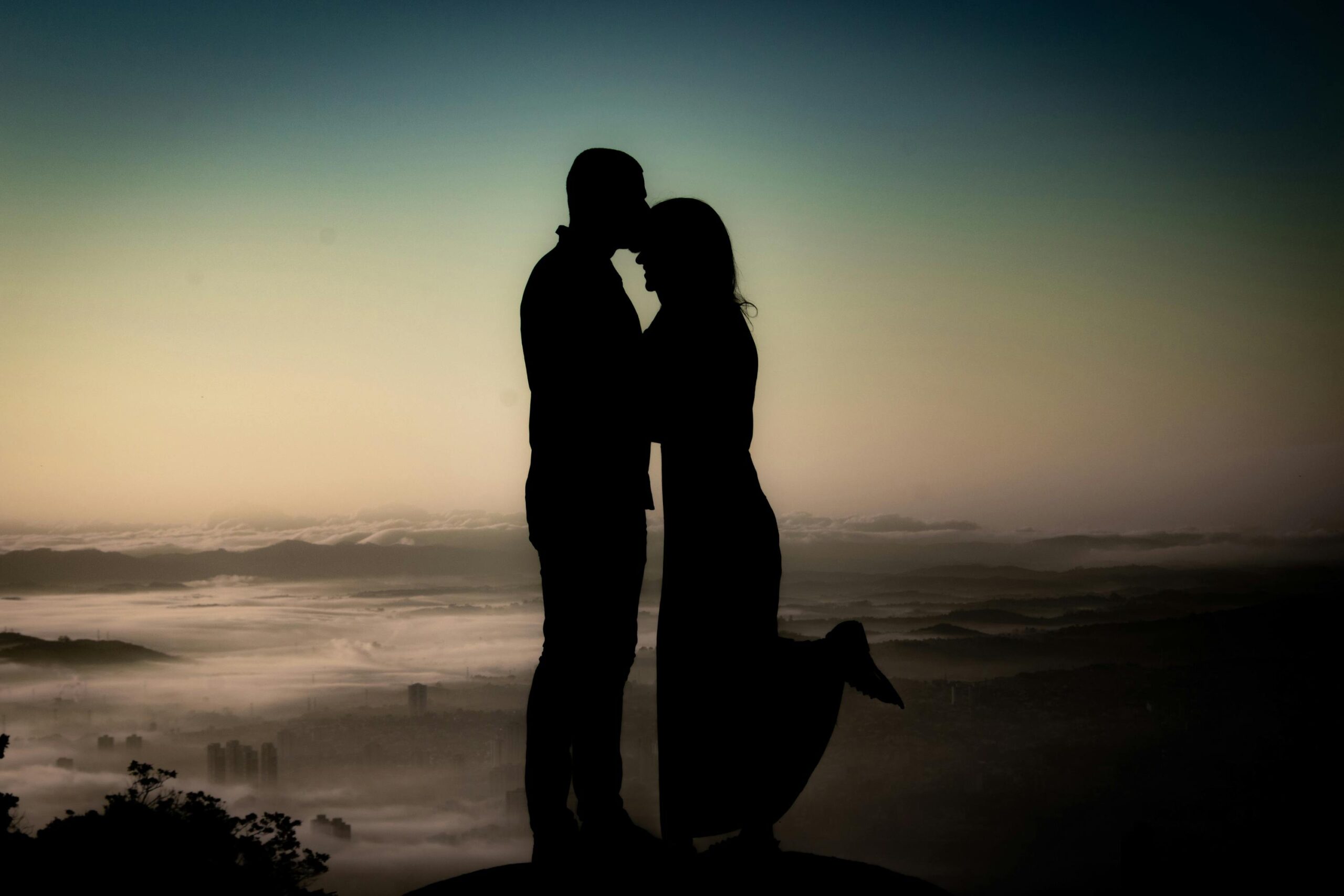 Silhouette of a couple sharing a tender moment at sunset in Mogi das Cruzes, Brazil.