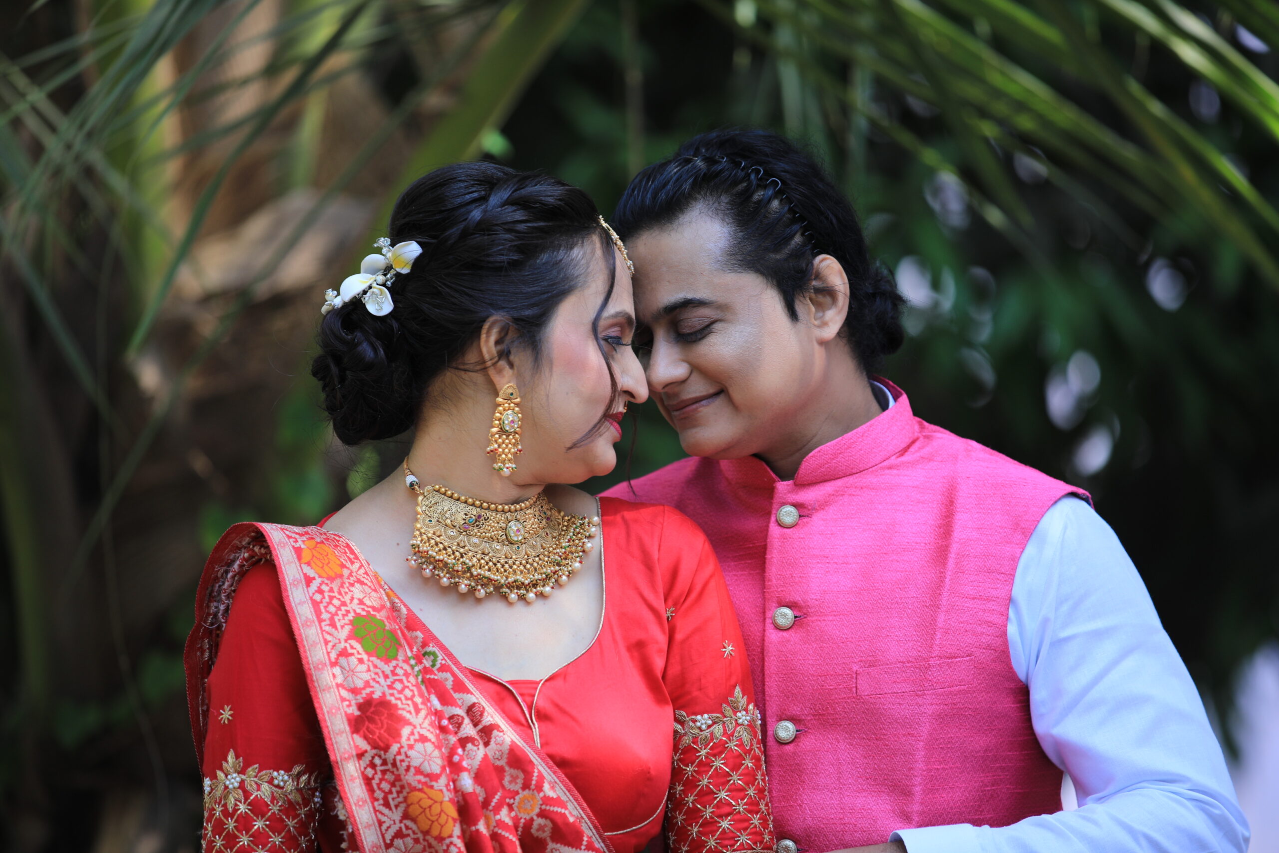 A romantic portrait of an Indian couple in traditional attire, surrounded by nature.